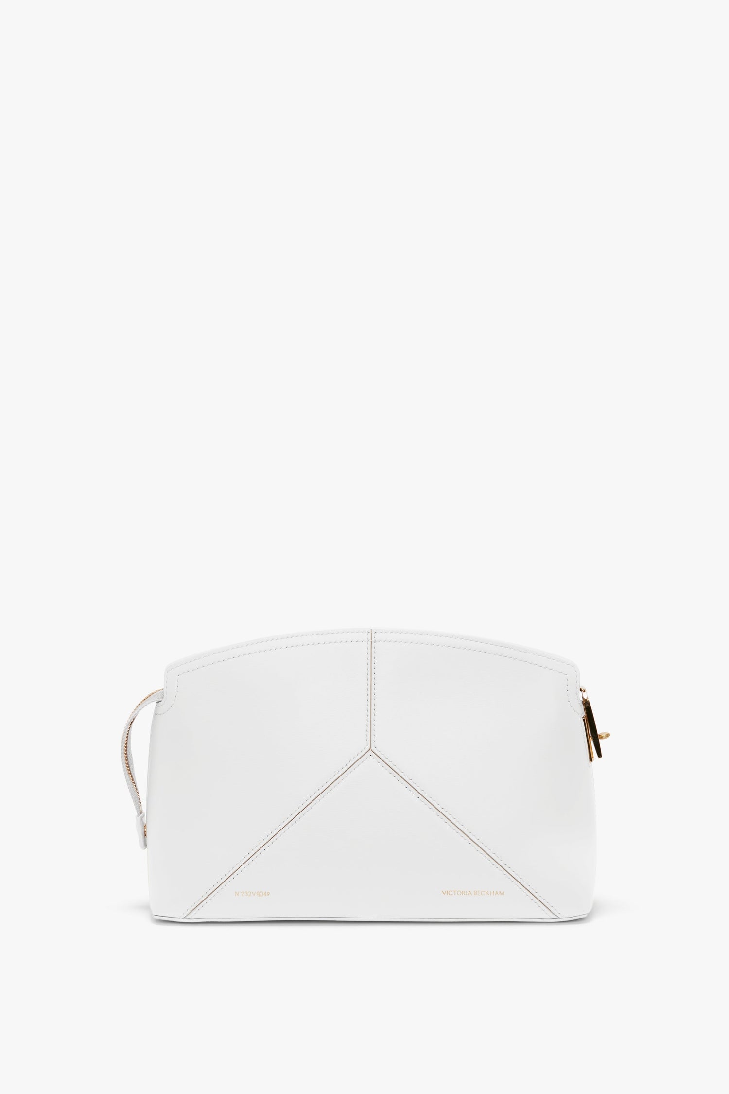 An **Exclusive Victoria Clutch Bag In White Leather** with geometric stitching, gold zipper, and minimal branding showcases a structured design in true **Victoria Beckham** fashion.