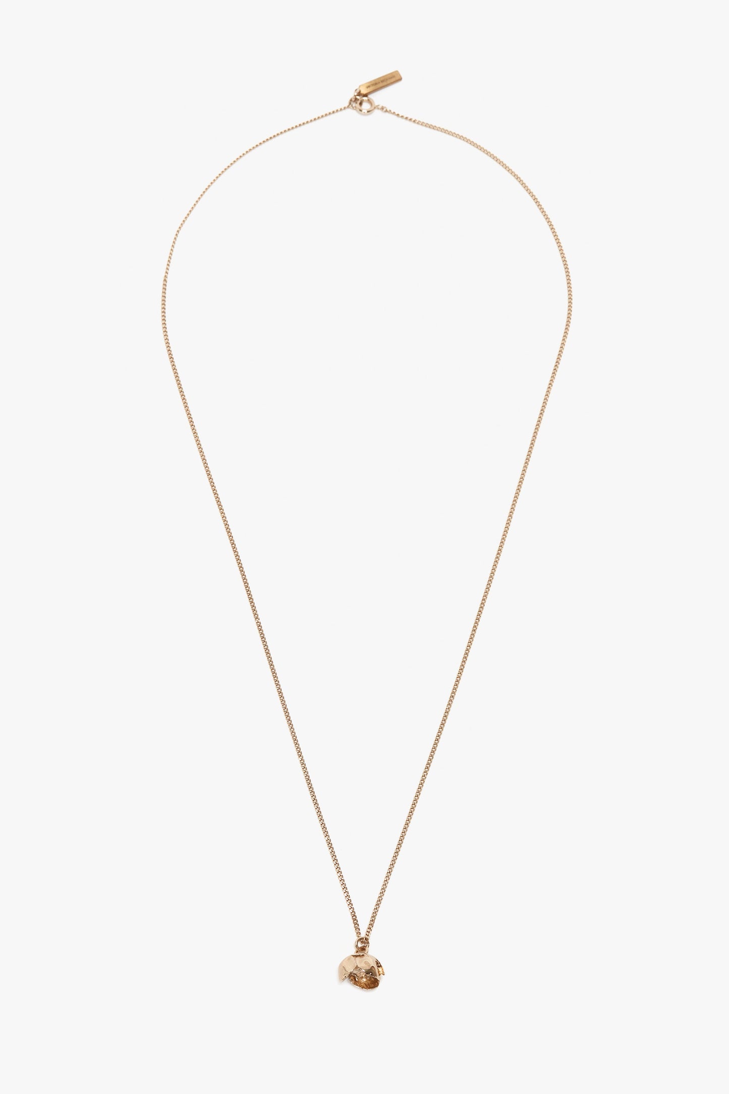 A gold chain necklace featuring a small, intricately detailed Camellia Flower pendant, handcrafted in Italy and displayed against a plain white background is replaced with the Exclusive Camellia Flower Necklace In Gold by Victoria Beckham.