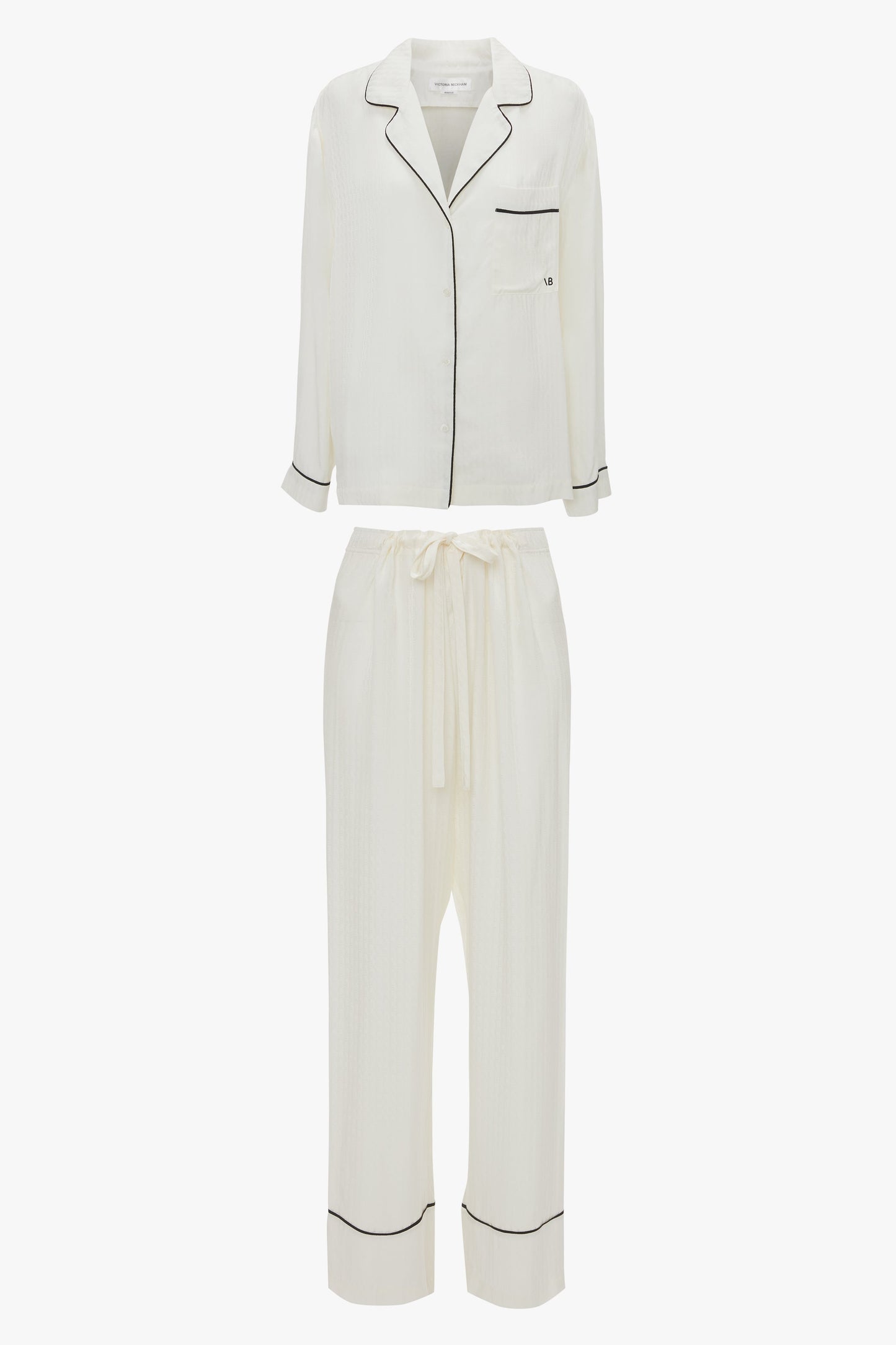 Experience ultimate comfort in the Victoria Beckham VB Monogram Pyjama Sleep Set In Ivory. The luxurious loungewear includes a long-sleeve button-up shirt featuring a chest pocket and matching pants with an elastic waistband and drawstring.