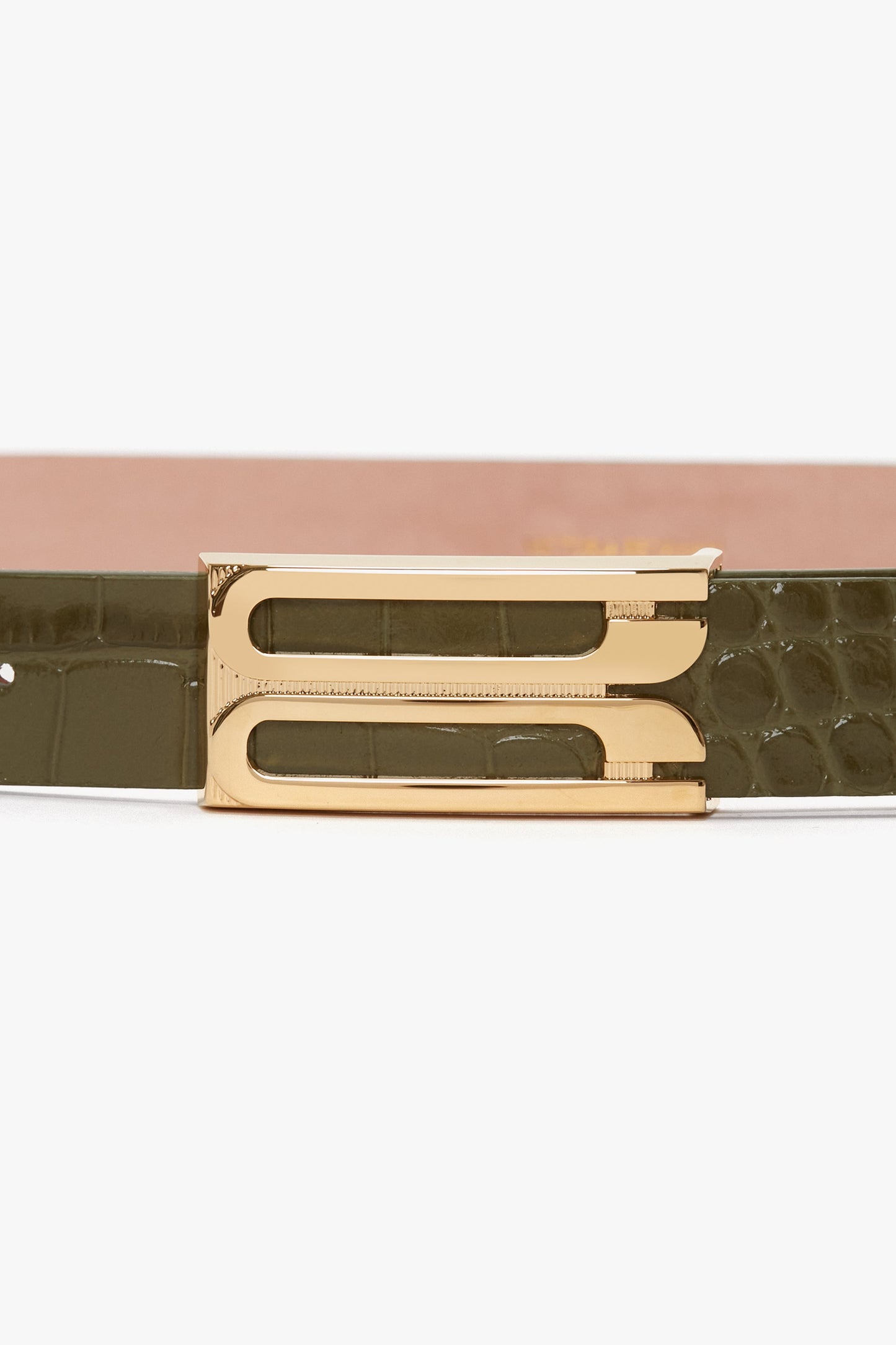 A close-up of the Victoria Beckham Exclusive Frame Belt In Khaki Croc Embossed Calf Leather with gold hardware.