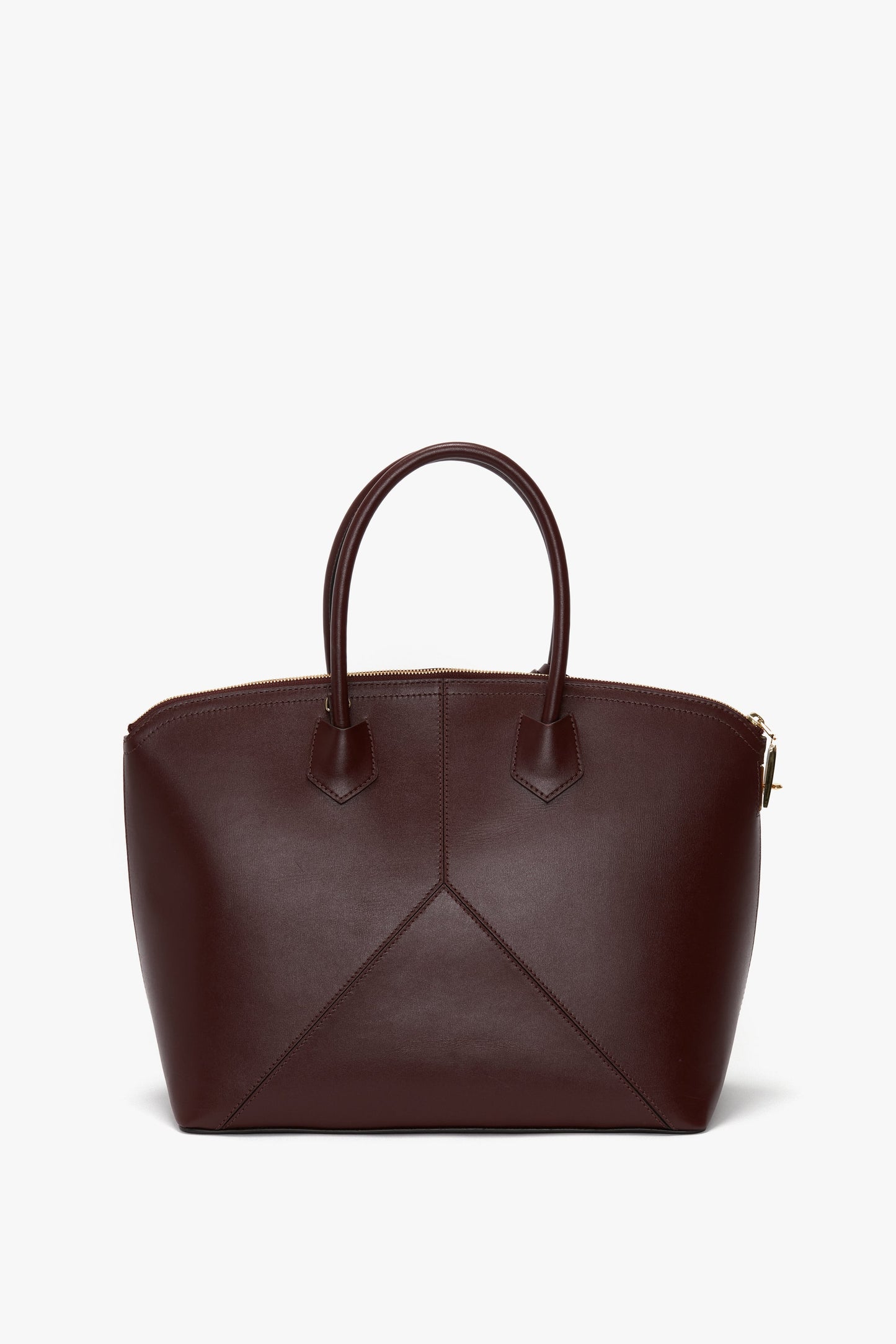 A Victoria Beckham Victoria Bag In Burgundy Leather with double handles, angular stitching on the front, an adjustable strap, and a zippered top closure.