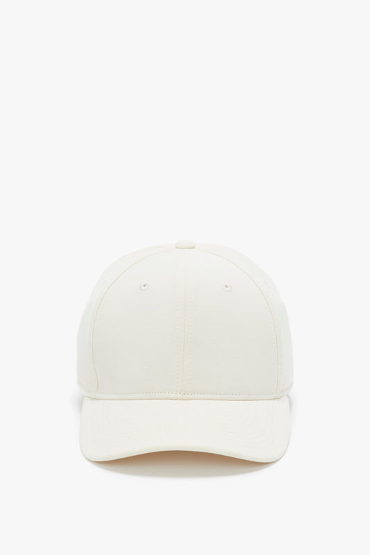 Front view of a plain beige Logo Cap In Antique White by Victoria Beckham against a white background.