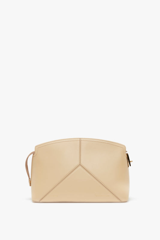 A Victoria Beckham Victoria Clutch Bag In Sesame Leather with geometric stitching, featuring a zipper closure and a small handle on the left side, perfect for adding an SS24 runway-inspired touch to your look.