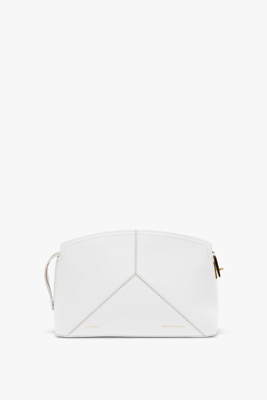 An **Exclusive Victoria Clutch Bag In White Leather** with geometric stitching, gold zipper, and minimal branding showcases a structured design in true **Victoria Beckham** fashion.