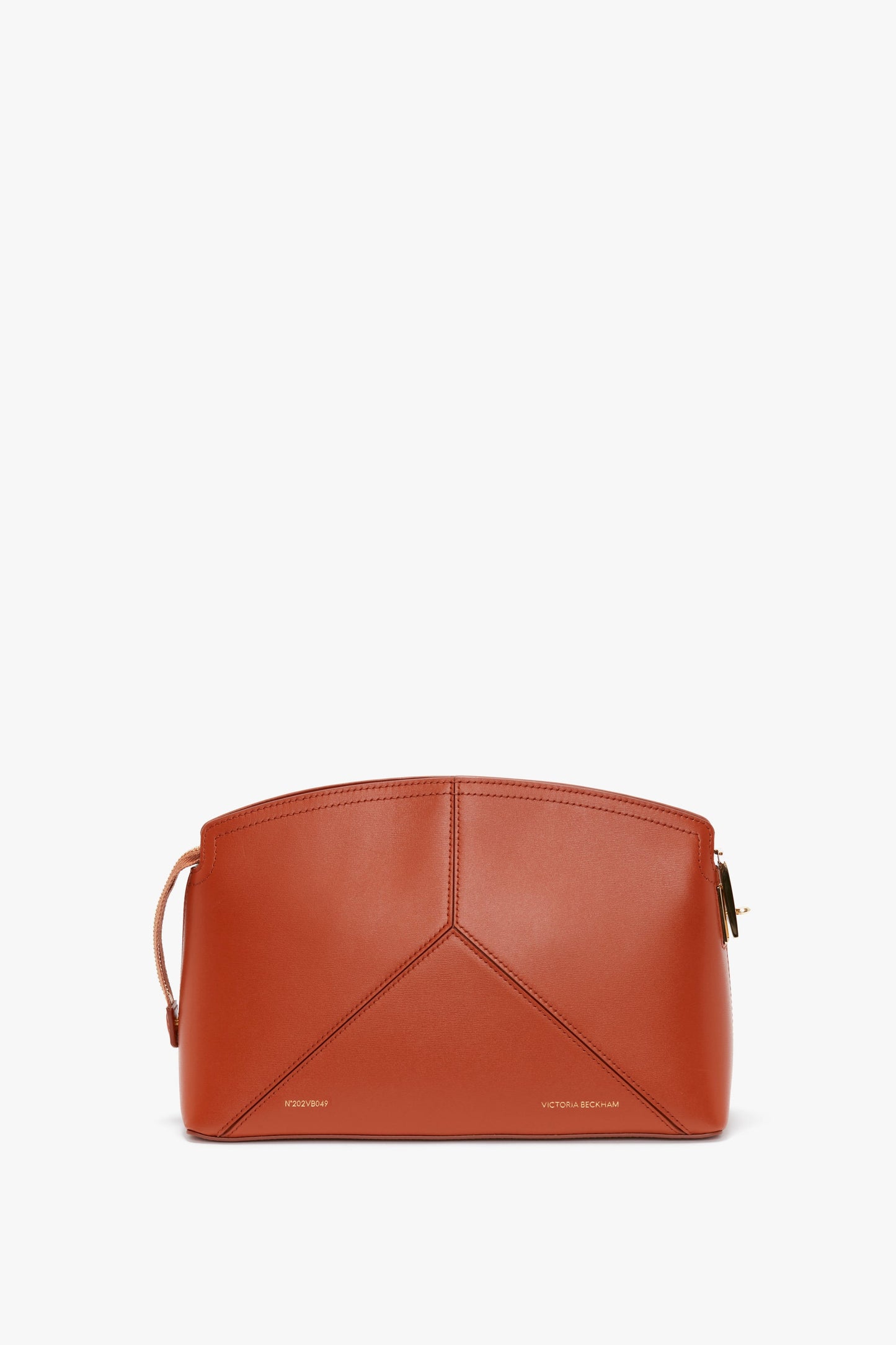 A Victoria Beckham Victoria Clutch Bag In Tan Leather with minimalistic design and subtle stitching, featuring a small handle on the side, a branded padlock, and a zip closure.