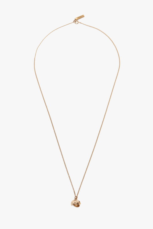 A gold chain necklace featuring a small, intricately detailed Camellia Flower pendant, handcrafted in Italy and displayed against a plain white background is replaced with the Exclusive Camellia Flower Necklace In Gold by Victoria Beckham.