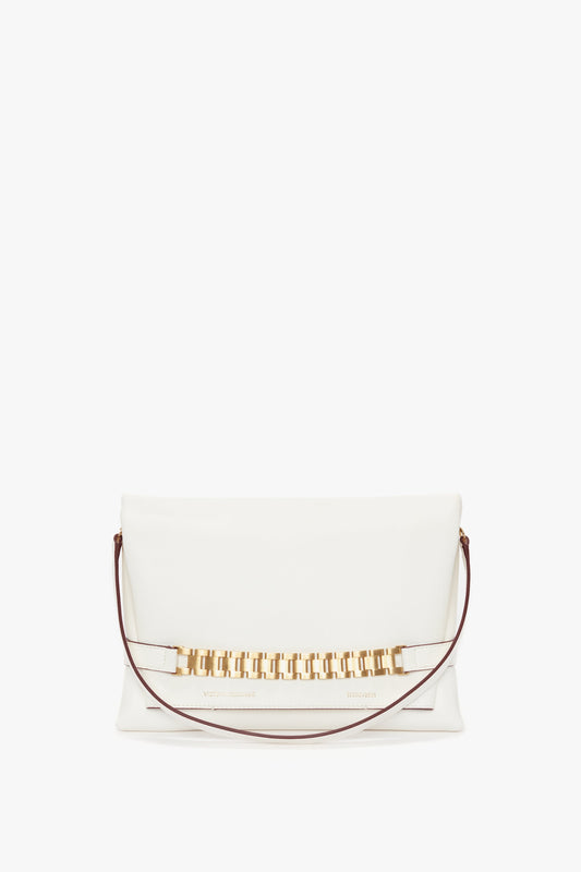 A white **Chain Pouch Bag With Strap In White Leather** crafted from tactile Nappa leather, featuring a gold-tone rectangular link chain accent and a thin brown detachable shoulder strap by **Victoria Beckham**.