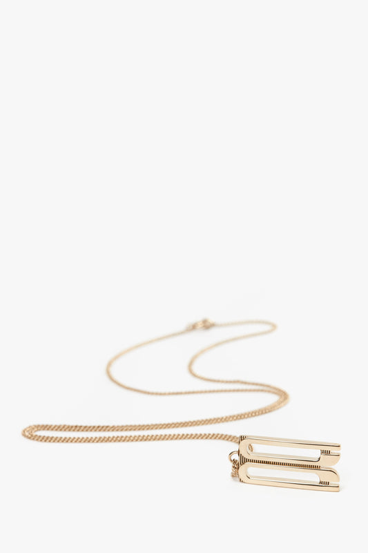 This stunning gold-plated brass necklace features a paperclip-shaped pendant on a delicate chain, reminiscent of the chic elegance seen in the Victoria Beckham Exclusive Frame Necklace In Gold.