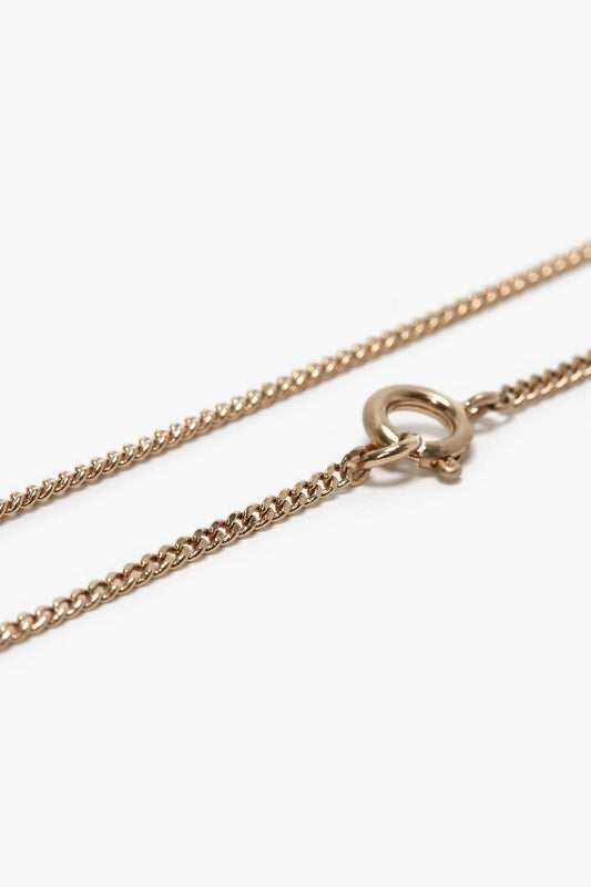 Close-up of the Victoria Beckham Exclusive Long Fine Chain In Gold, made of gold-plated brass with a spring ring clasp, reminiscent of Victoria Beckham's elegant style.
