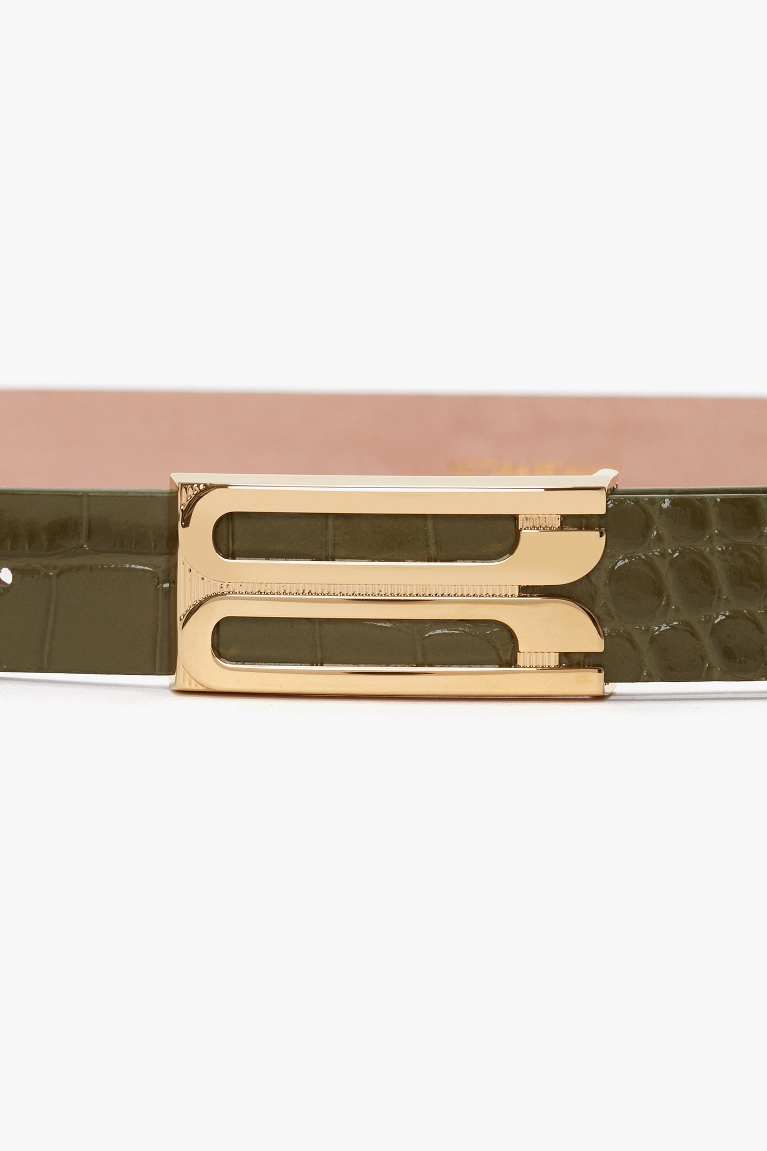 A close-up of the Victoria Beckham Exclusive Frame Belt In Khaki Croc Embossed Calf Leather with gold hardware.