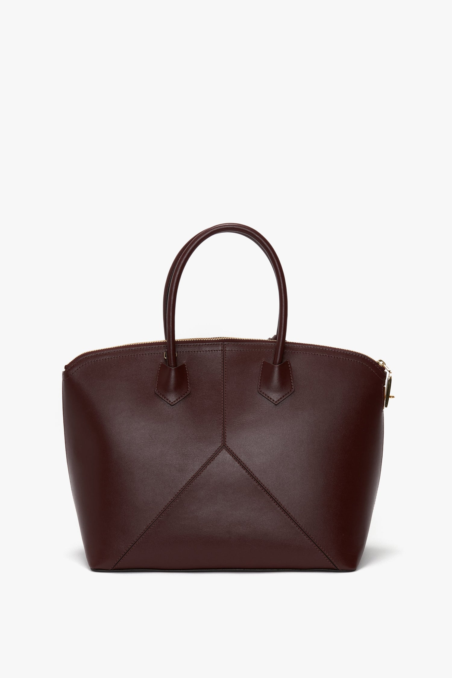 A Victoria Beckham Victoria Bag In Burgundy Leather with double handles, angular stitching on the front, an adjustable strap, and a zippered top closure.