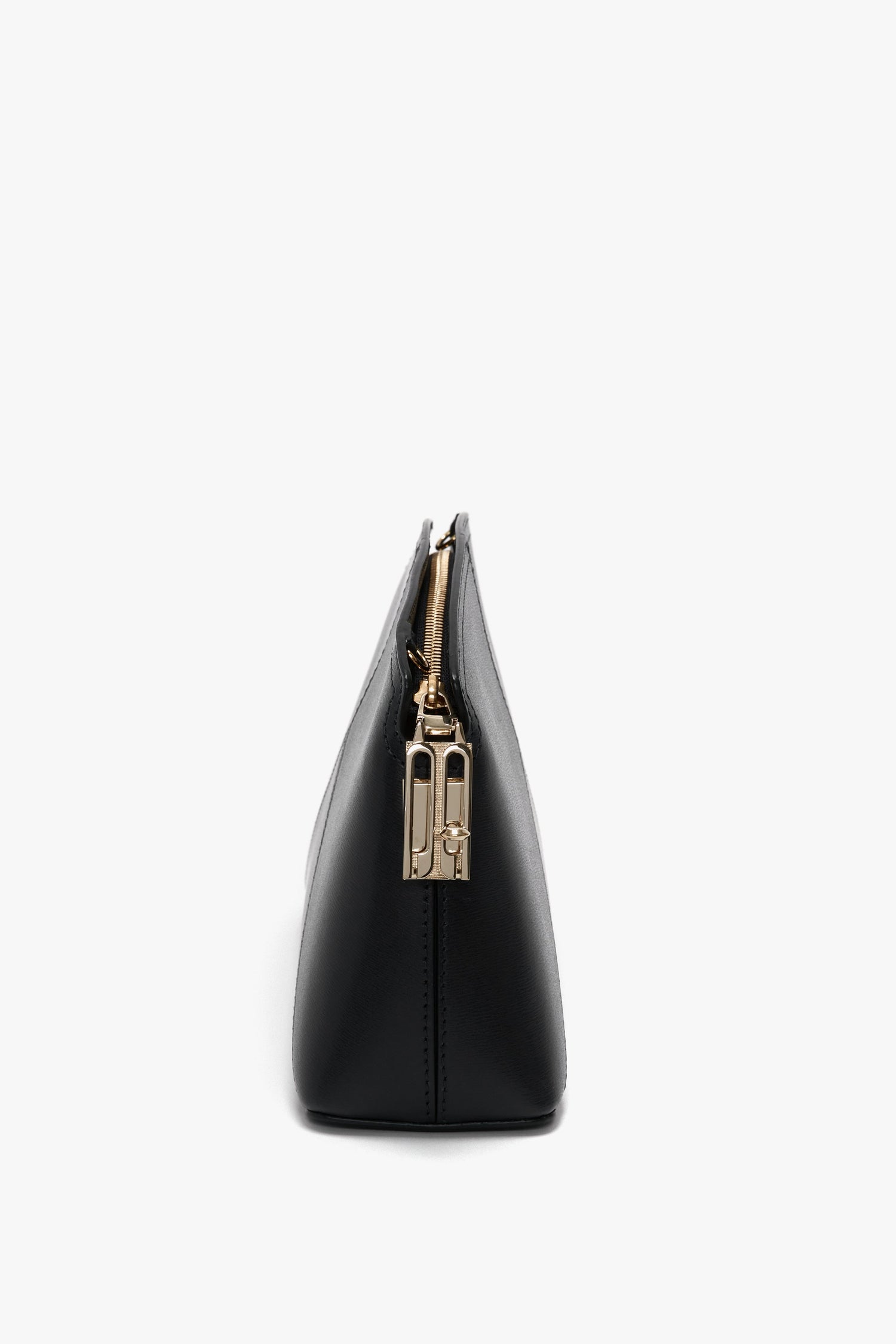 Side view of a black leather Victoria Beckham Victoria Crossbody Bag In Black Leather with textured calf leather, featuring a visible gold-toned zipper and a small padlock charm.