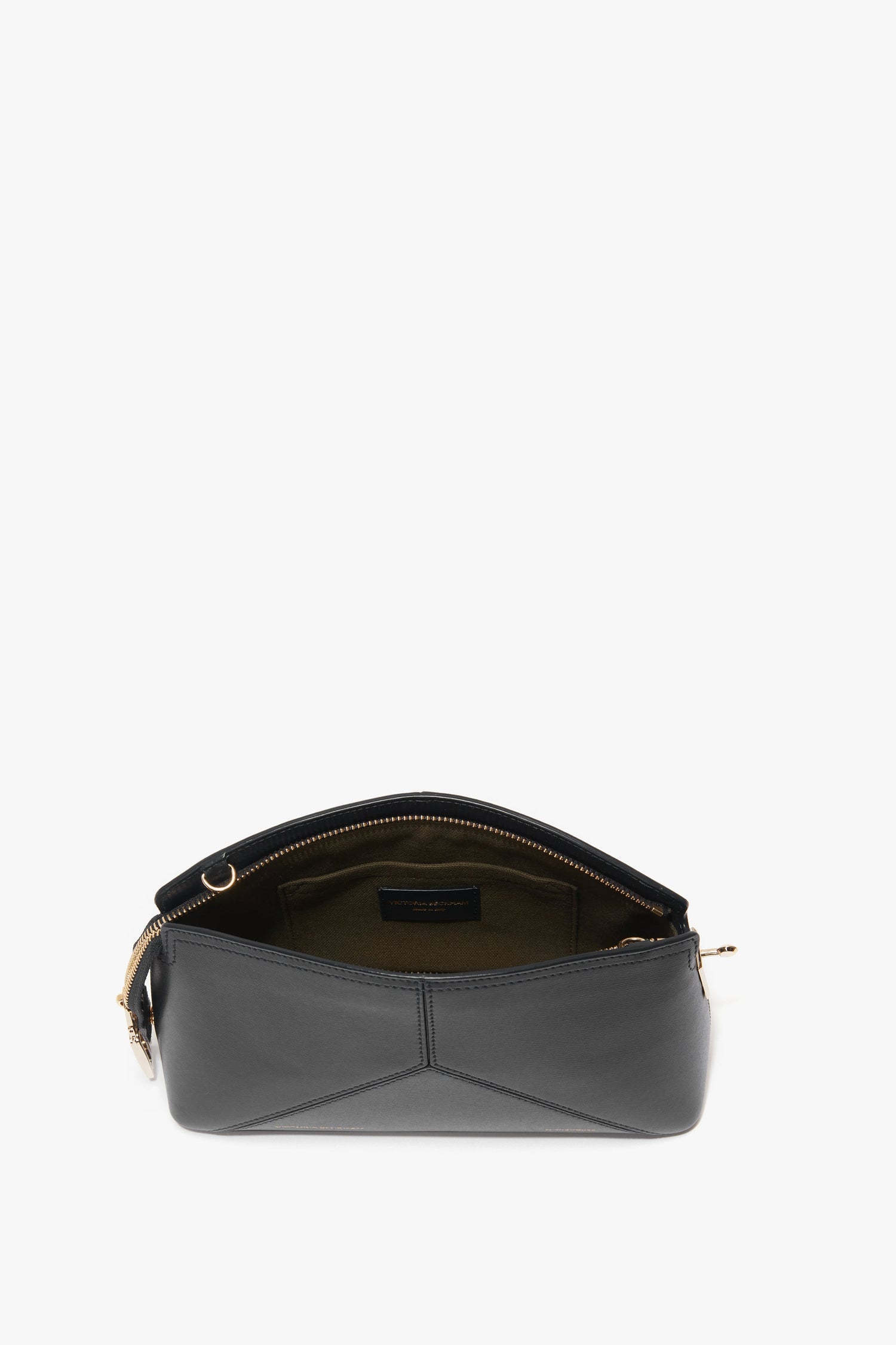 Image of an open, black Victoria Beckham Victoria Crossbody Bag In Black Leather made from textured calf leather with gold hardware, showing the interior lining. The bag has a zippered opening and an adjustable strap, all in a sleek, minimalist design.