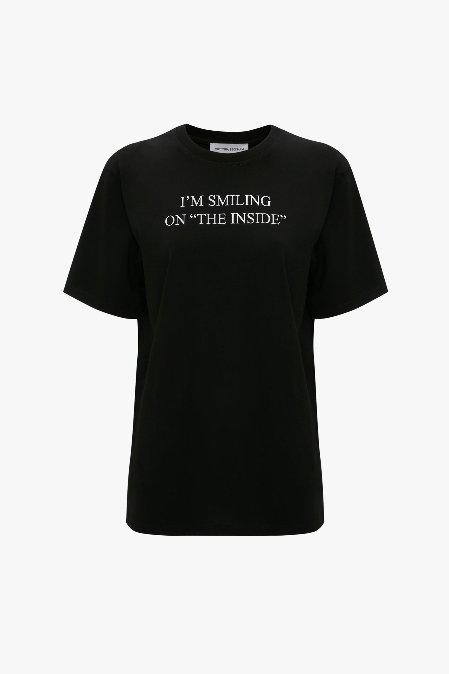 A relaxed fit, black slogan T-shirt made from organic cotton with "I'M SMILING ON 'THE INSIDE'" printed in white on the front. The I'm Smiling On The Inside Slogan T-Shirt in Black by Victoria Beckham.